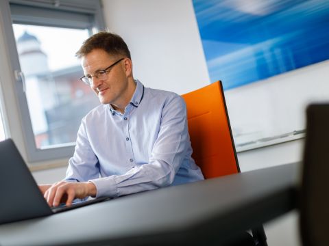 Geschäftsführer der Agentur arbeitet am Macbook