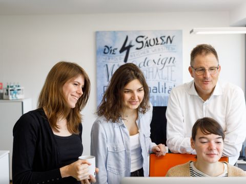 Aysberg-Mitarbeiter gemeinsam vor einer Website