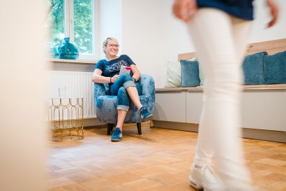 Frau sitzt im Wartezimmer Gynpraxis Dilenge Freising auf einem Stuhl