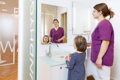 Arzthelferin mit Kind beim Zähneputzen Kieferorthopädie Heilmeier Freising