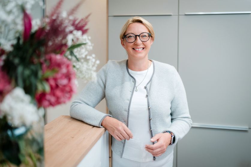 Justine Börzsönyi-Dilenge steht am Empfang Gynpraxis Dilenge Freising