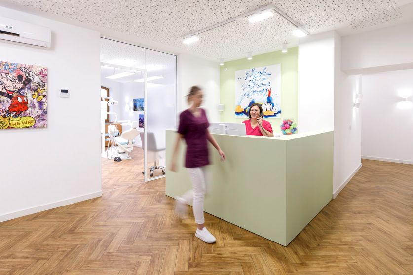 Empfangsmitarbeiterin telefoniert am Empfang der kieferorthopädischen Praxis Heilmeier Freising